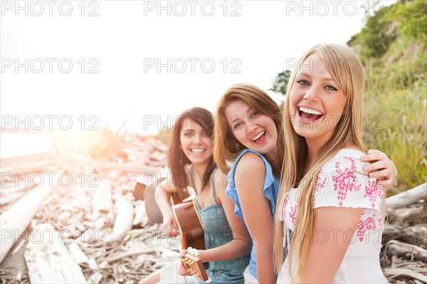 Portrait of young women with guitar on beach. Photo: Take A Pix Media