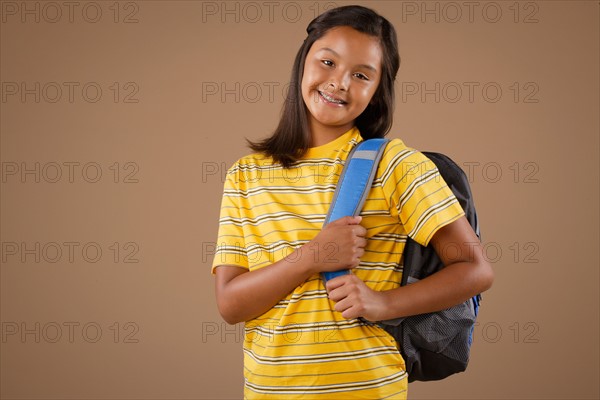 Studio portrait of girl (10-11) wearing backpack. Photo : Rob Lewine