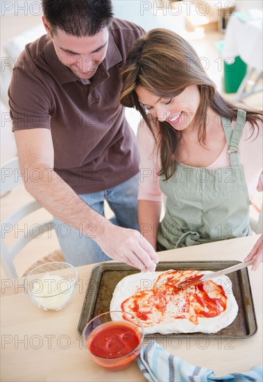 Smiling couple preparing pizza. Photo: Jamie Grill