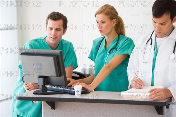 Team of doctors looking at computer.