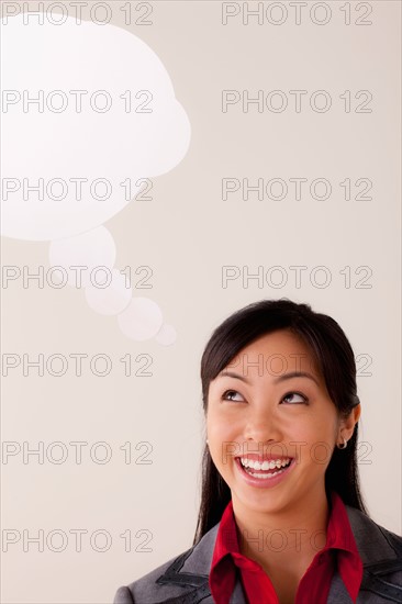 Studio portrait of businesswoman with thought bubble. Photo : Rob Lewine