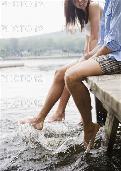 Roaring Brook Lake, Close up of couple sitting on pier by lake. Photo: Jamie Grill