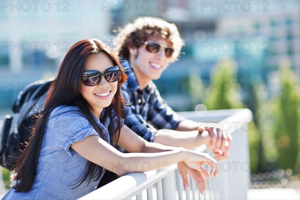 Couple standing by banister outdoors. Photo: Take A Pix Media