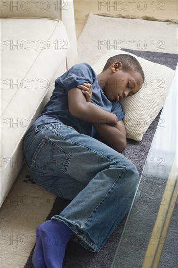 Boy (12-13) sleeping on carpet. Photo: Rob Lewine