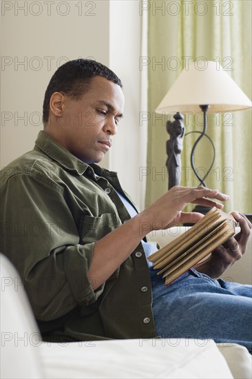 Man reading book at home. Photo: Rob Lewine
