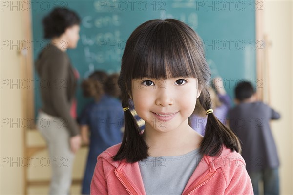 Portrait of smiling girl (6-7) with classmates in background. Photo: Rob Lewine