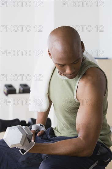 Young man lifting weights in gym. Photo: Rob Lewine