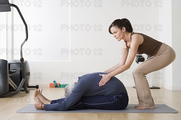 Woman assisting man in exercise in gym. Photo: Rob Lewine