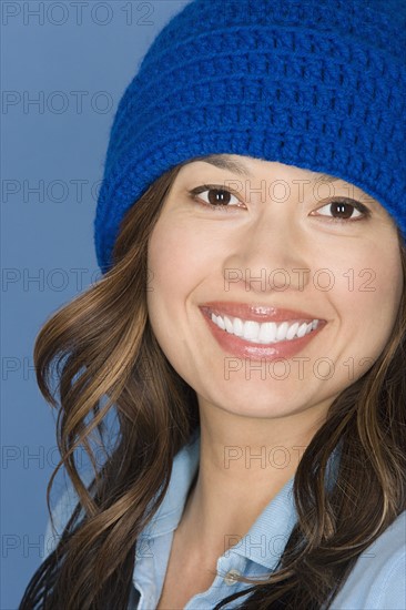 Portrait of happy asian woman wearing blue knit hat. Photo: Rob Lewine