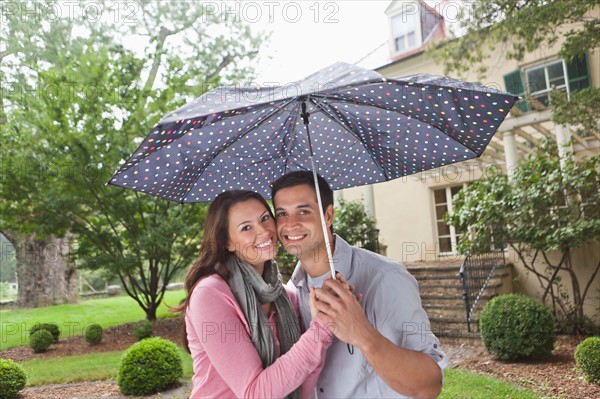USA, New Jersey, Portrait of couple holding umbrella. Photo: Tetra Images