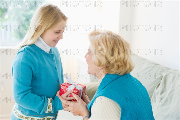 Granddaughter (8-9) receiving gift from grandmother.