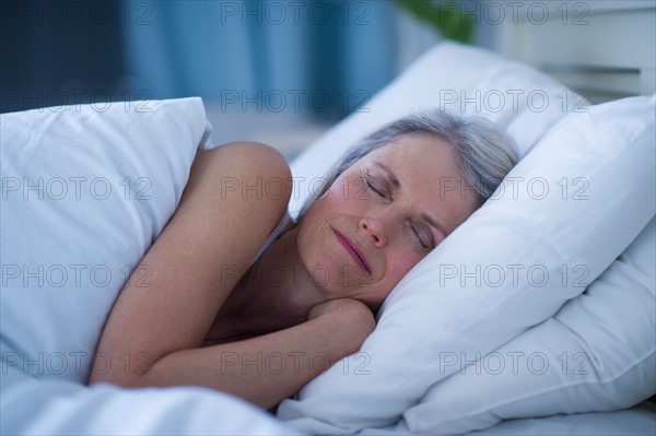 Senior woman sleeping in bed .