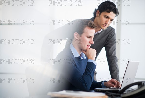 Two businessmen working with laptop.