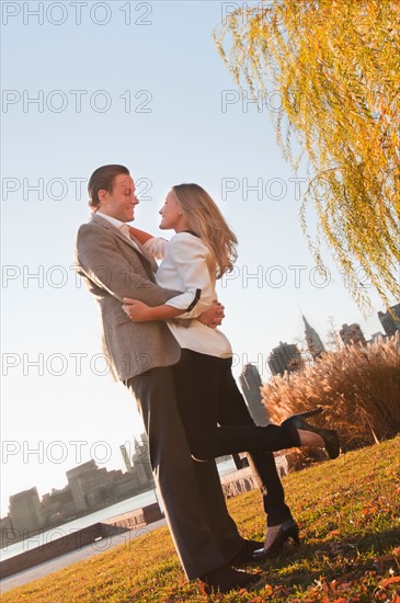 USA, New York, Long Island City, Young couple embracing in park. Photo : Daniel Grill