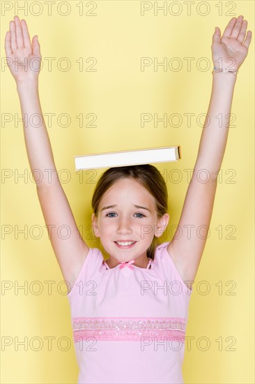Studio shot portrait of teenage girl with arms raised, waist up. Photo : Rob Lewine