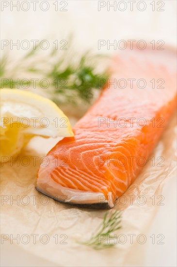 Close up of salmon meat with lemon and herb, studio shot. Photo : Jamie Grill