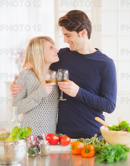 Couple preparing food in kitchen and making toast. Photo : Daniel Grill