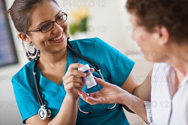 Young female nurse attending patient. Photo : Tim Pannell