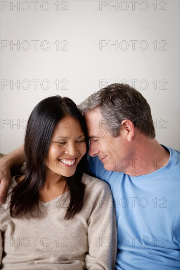 Couple in close embrace sitting on sofa. Photo : Rob Lewine