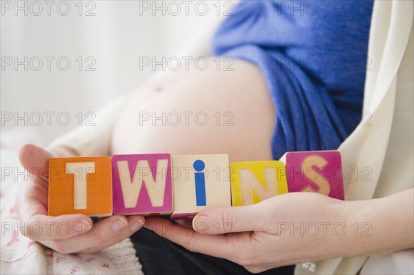 Pregnant woman holding wooden blocks . 
Photo: Jamie Grill