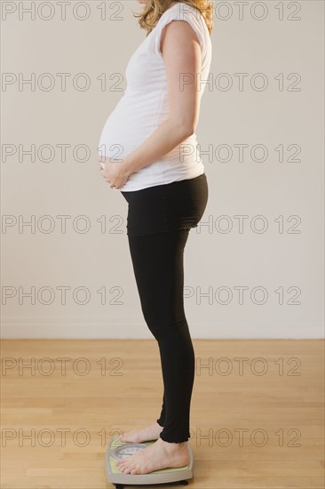 pregnant woman standing on weight scale. 
Photo: Jamie Grill