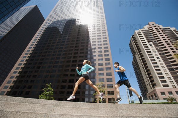 USA, California, Los Angeles, Young man and young woman running in city. 
Photo: Erik Isakson