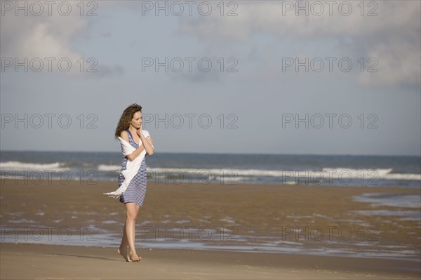 France, Pas-de-Calais, Escalles, Young woman strolling on empty beach. 
Photo: Jan Scherders