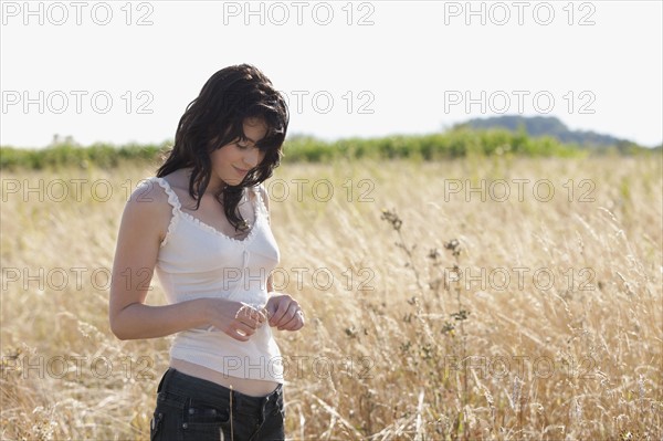 France, Picardie, Albert, Young woman standing on cornfield. 
Photo : Jan Scherders