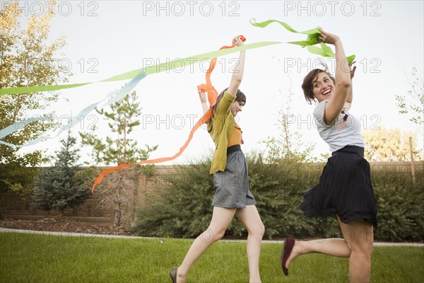 Two happy female friends playing in domestic garden. 
Photo : Jessica Peterson