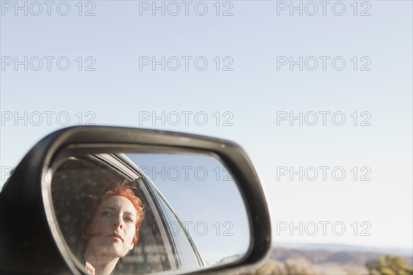 Young woman reflecting in car wing. 
Photo: Jessica Peterson