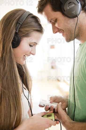 Happy young couple listening to music. Photo: Jamie Grill