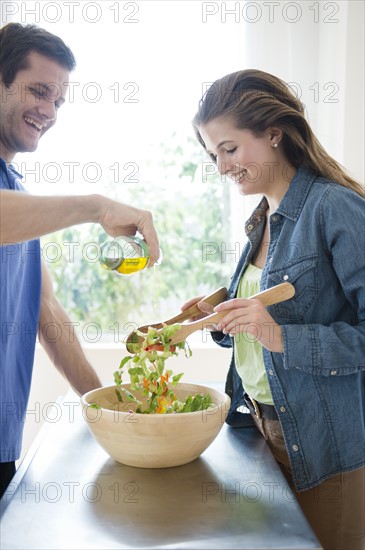 Happy young couple making salad. Photo: Jamie Grill