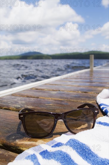 Close-up of sunglasses and towel on jetty. Photo: Daniel Grill