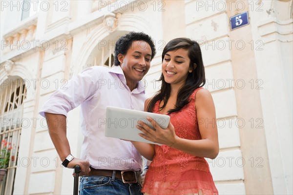 France, Cassis, Couple using digital tablet on street. Photo: Mike Kemp