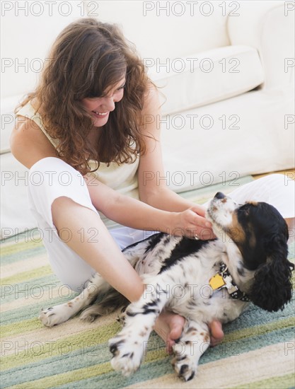 Portrait of young woman playing with dog. Photo: Daniel Grill