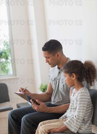 Father with daughter (6-7) waiting for doctor's appointment.