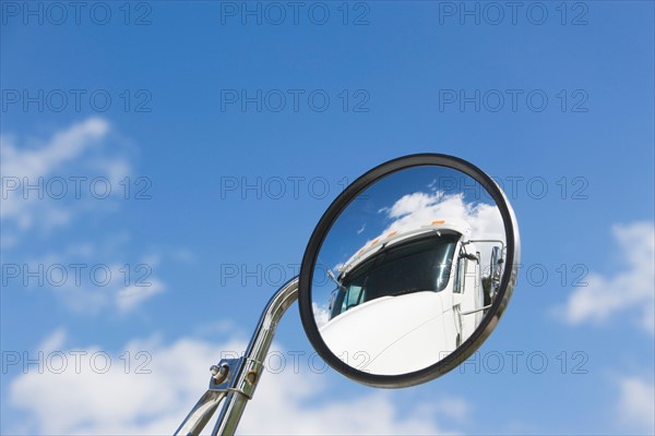 Reflection of semi-truck in side view mirror