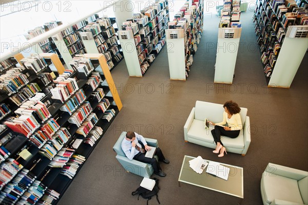 Elevated view of man and woman reading in library