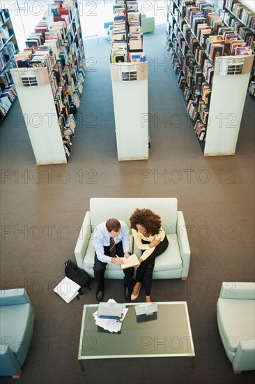 Elevated view of man and woman reading in library