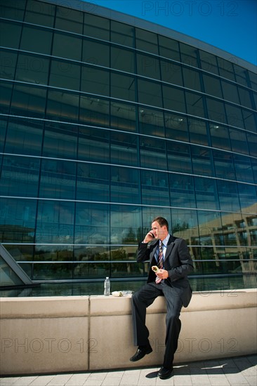 Young man taking lunch brake on ledge