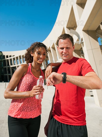 Man and woman checking time after jogging