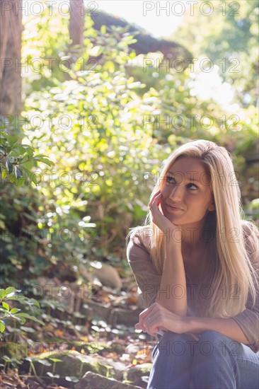 Woman sitting in forest. Photo: Jamie Grill