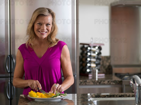 Portrait of mature woman preparing salad. Photo : Dan Bannister