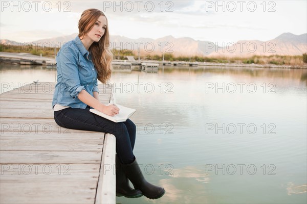 Portrait of young woman sitting on jetty. Photo: Jessica Peterson