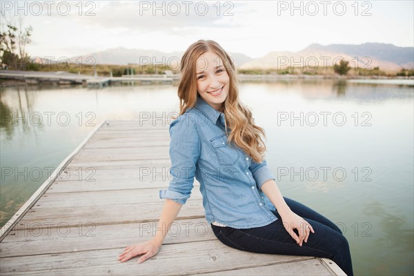 Portrait of young woman sitting on jetty. Photo: Jessica Peterson