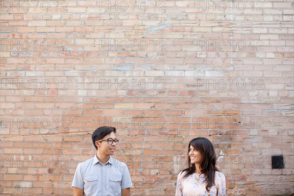 Couple standing in front of brick wall. Photo: Jessica Peterson