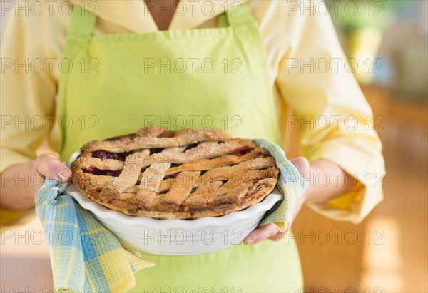 Woman holding freshly baked cake.