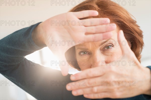 Hands framing face of businesswoman.