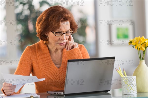 Senior woman working on laptop at home.