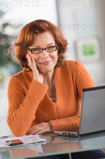 Senior woman working on laptop at home.